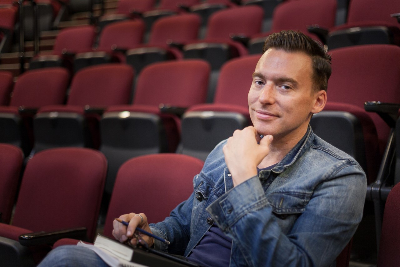 Comediam Ron Pederson sitting in an empty theatre.